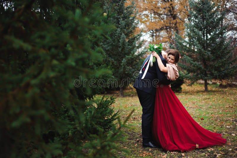 Romantische Umarmung von Jungvermählten Paar geht in den Park lizenzfreie stockfotografie Romantische Umarmung von Jungvermählten Paar geht in den Park lizenzfreie stockfotografie