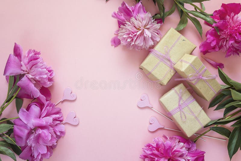 Romantisk bakgrund med pioner, gåvaaskar och hjärtor på rosa färger royaltyfri foto Romantisk bakgrund med pioner, gåvaaskar och hjärtor på rosa färger royaltyfri foto