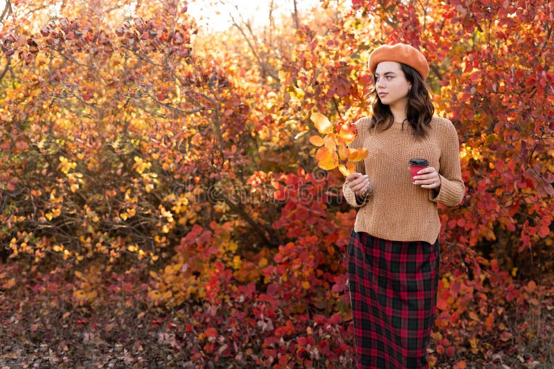Romantisk höstkvinna med brun hårdeg kaffe och orange höstlöv. falla modeflicka utomhus arkivfoto