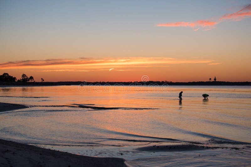 Romantiskt samla för man- och kvinnakonturskal på stranden på solnedgången arkivfoto Romantiskt samla för man- och kvinnakonturskal på stranden på solnedgången arkivfoto