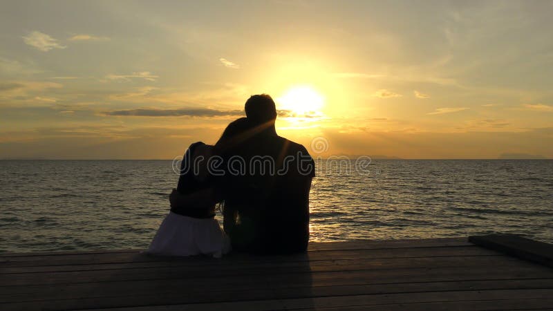 Romantyczna para na plaży przy kolorowym zmierzchem na tle