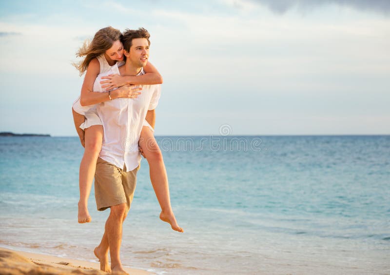 Romantyczna szczęśliwa para na plaży przy zmierzchem obraz royalty free Romantyczna szczęśliwa para na plaży przy zmierzchem obraz royalty free
