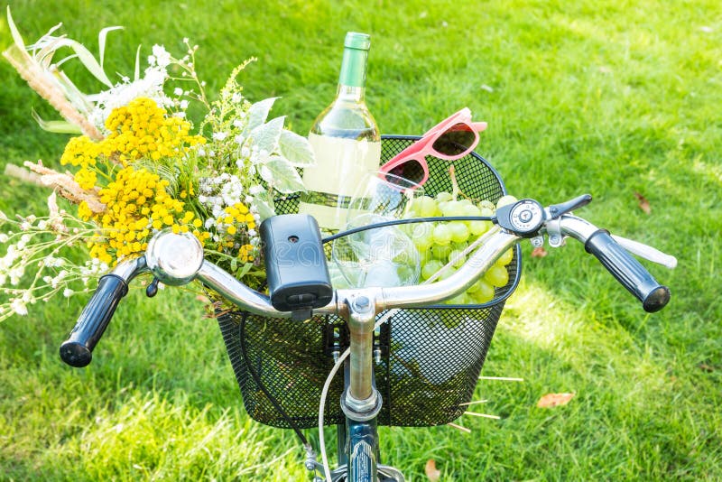 Romantyczny pinkin - kwiaty i wino w rowerowym koszu fotografia stock Romantyczny pinkin - kwiaty i wino w rowerowym koszu fotografia stock