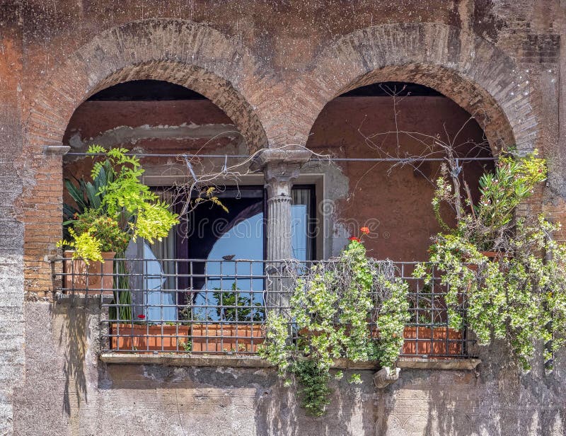 Rome, Italy, front of a house and double arch small terrace with flowers and plants royalty free stock photo