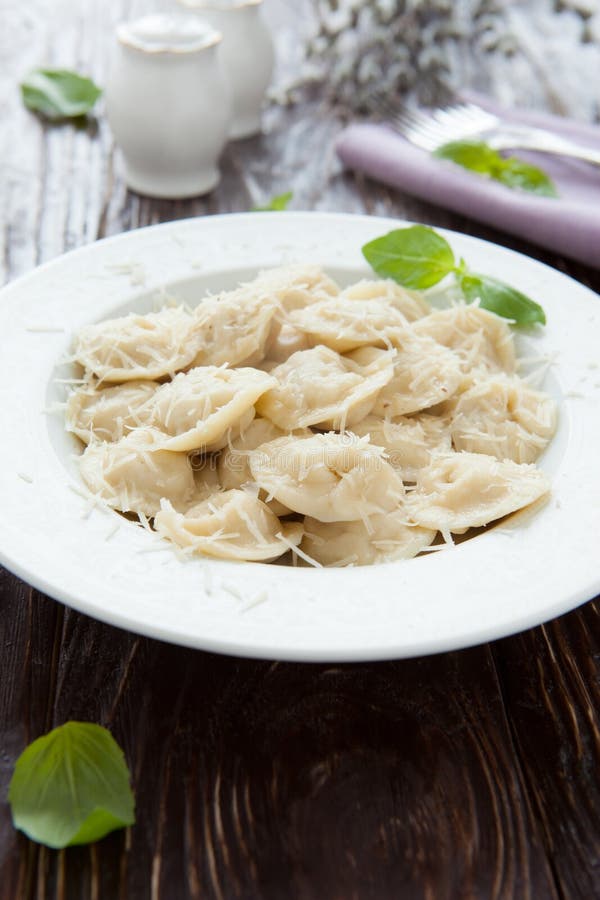 Round meat ravioli with basil and parmesan, closeup. Round meat ravioli with basil and parmesan, closeup