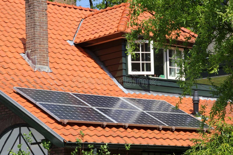 Modern solar panels as an alternative energy source on scenic red tiled roof, Netherlands