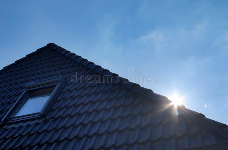 Roof window in velux style with black roof tiles