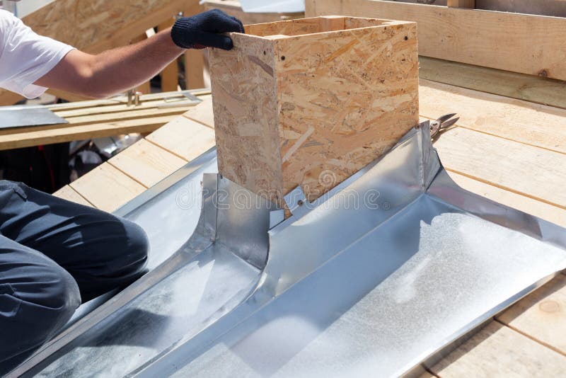 Roofer Builder Worker Attach Metal Sheet To the Chimney. Stock Photo