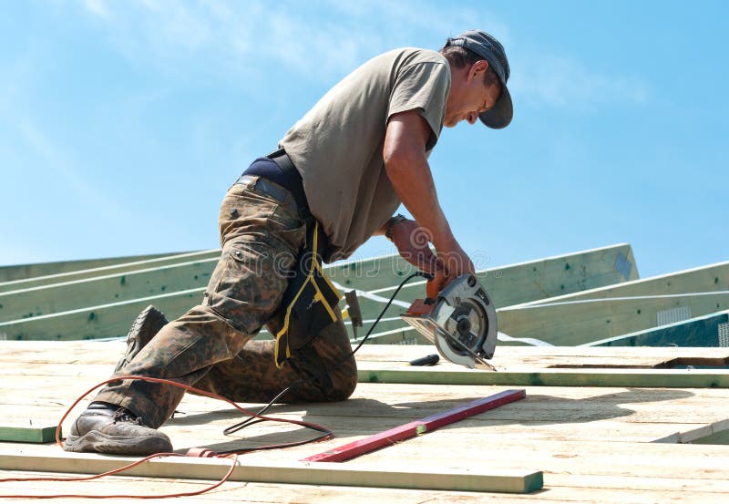 Worker (roofer) on rooftop using rotary drill. Worker (roofer) on rooftop using rotary drill.