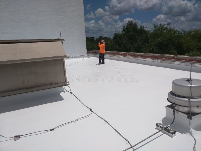 Roofer que examina un tejado plano comercial, techumbre de EPDM