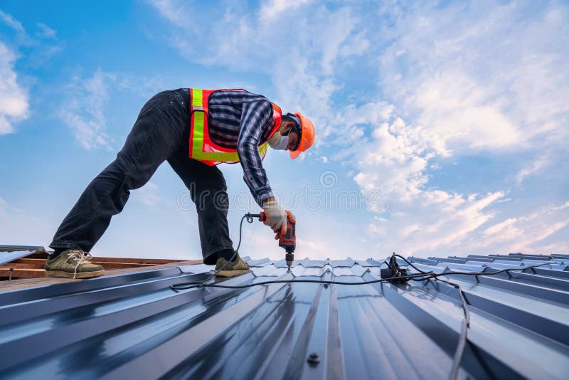 Roofer working on roof structure of building in construction site, Roof metal sheet construction concept. Roofer working on roof structure of building in construction site, Roof metal sheet construction concept.