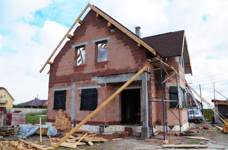 Roofing Construction and Building New Ceramic Bricks House with Modular Chimney, Skylights, Attic, Facade and Eaves Exterior. Install, Repair Asphalt Shingles royalty free stock photography Roofing Construction and Building New Ceramic Bricks House with Modular Chimney, Skylights, Attic, Facade and Eaves Exterior. Install, Repair Asphalt Shingles royalty free stock photography