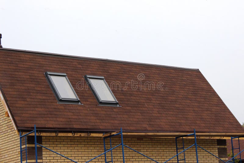 Roofing construction and building new house with skylights, new brick house with chimney. Modern Roof Skylight. Attic Skylights. Home Design. Roofing stock photography Roofing construction and building new house with skylights, new brick house with chimney. Modern Roof Skylight. Attic Skylights. Home Design. Roofing stock photography
