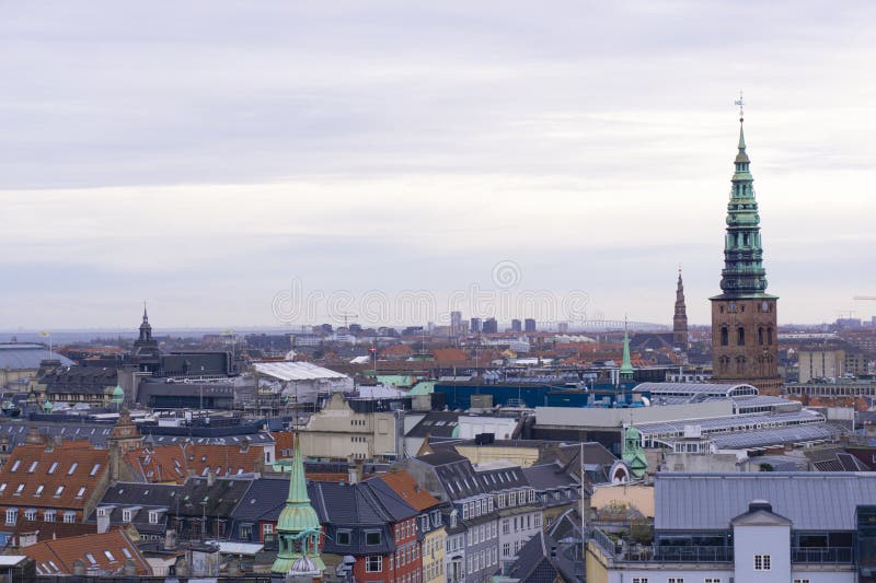 Panoramic view of Copenhagen's rooftops and spires from the top of the Round Tower, overlooking historic buildings.