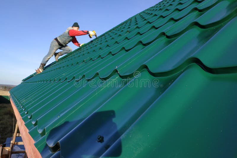 A rooftop worker attaches a metal tile to the roof base