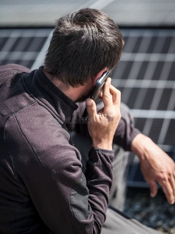Rooftop Worker Making Phone Calls With Mobile Phone During Installation 