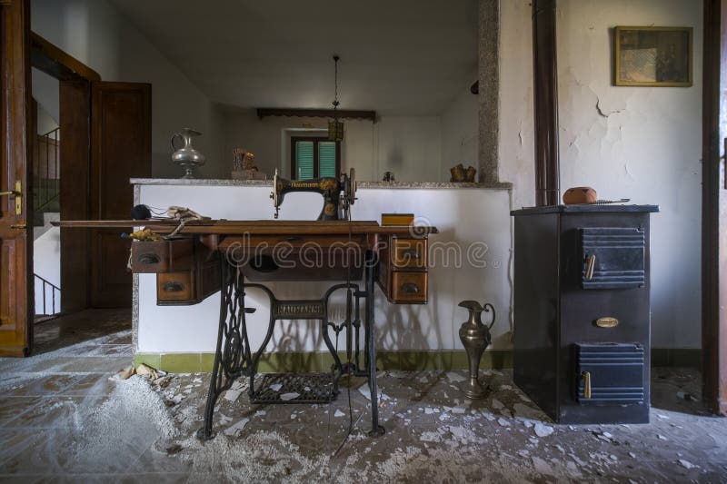 In a room, a vintage sewing machine rests on a wooden table royalty free stock image