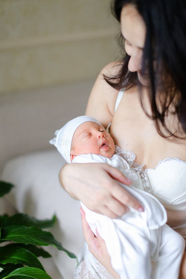 Ropa Que Lleva De Madre Americana Joven Que Detiene Al Bebé Recién Nacido Imagen de archivo - Imagen muchacha, cuidado: 119300401