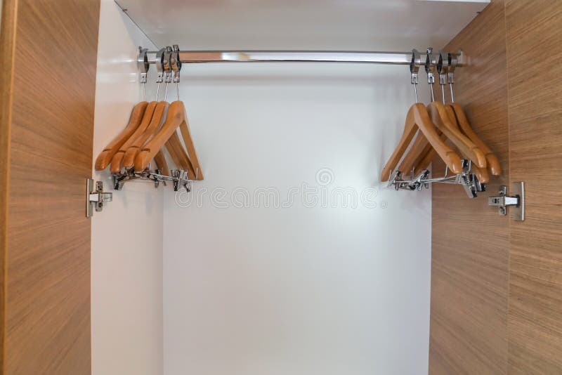 Ropa-suspensión de madera en guardarropa fotografía de archivo libre de regalías Ropa-suspensión de madera en guardarropa fotografía de archivo libre de regalías
