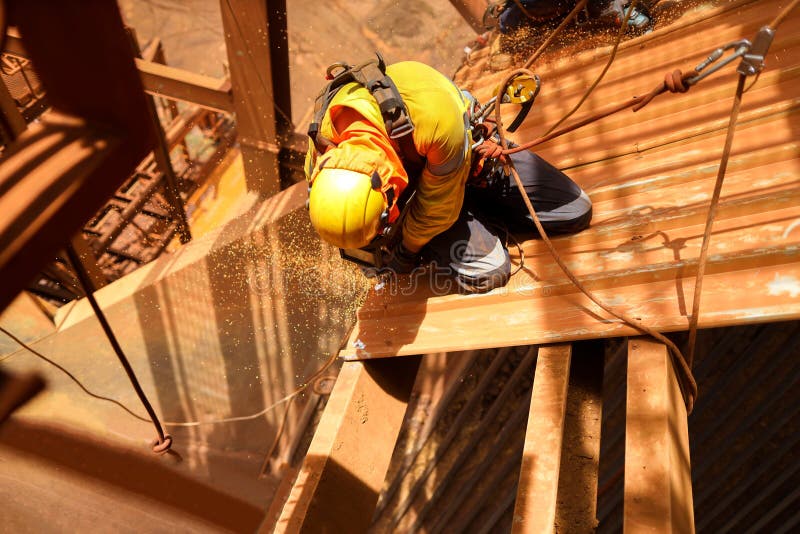 Rope access maintenance wearing safety harness, helmet abseiling with two ropes seating knee bend wearing a glove hand protection stock photos Rope access maintenance wearing safety harness, helmet abseiling with two ropes seating knee bend wearing a glove hand protection stock photos