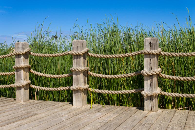 Rope and wooden post bannister railing. Boardwalk rail stock images, royalty-free photos and pictures