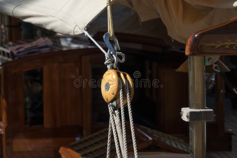 Rope pulley blocks marine vintage on an old Sailboat. Nautical detail on a dark background. Rope pulley blocks marine vintage on an old Sailboat. Nautical detail on a dark background