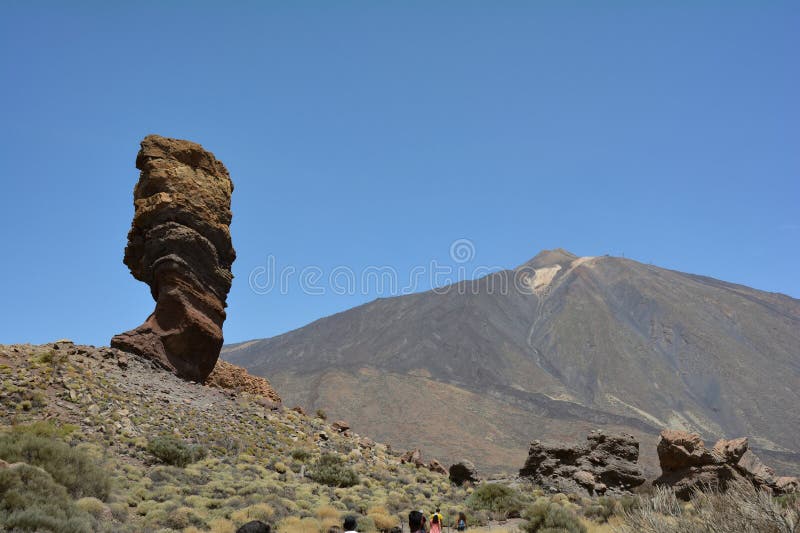 The bizarrely shaped Roque Cinchado rock of volcanic rock in Teide National Park on the Canary Island of Tenerife, Spain. With views of Mount Teide and blue skies. The bizarrely shaped Roque Cinchado rock of volcanic rock in Teide National Park on the Canary Island of Tenerife, Spain. With views of Mount Teide and blue skies