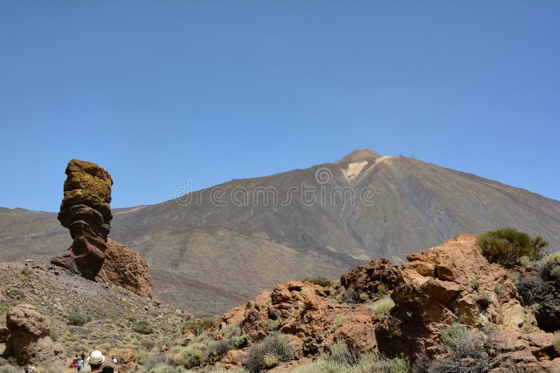 The bizarrely shaped Roque Cinchado rock of volcanic rock in Teide National Park on the Canary Island of Tenerife, Spain. With views of Mount Teide and blue skies. The bizarrely shaped Roque Cinchado rock of volcanic rock in Teide National Park on the Canary Island of Tenerife, Spain. With views of Mount Teide and blue skies