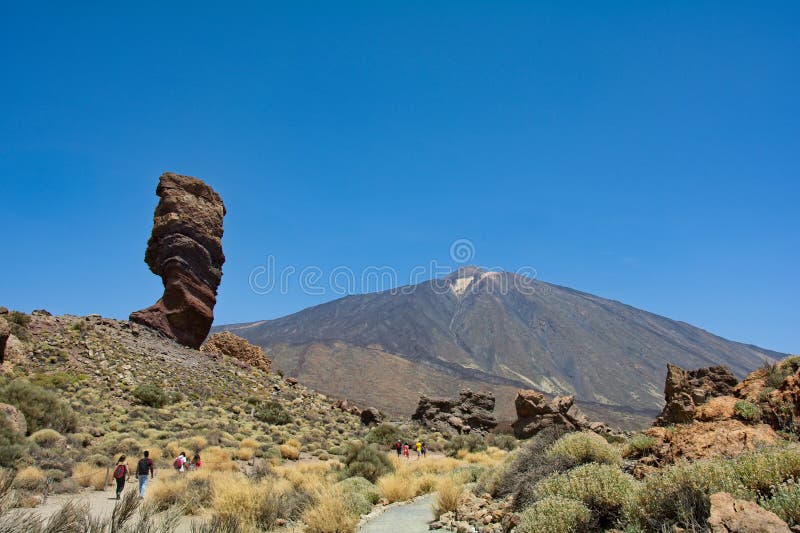 The bizarrely shaped Roque Cinchado rock of volcanic rock in Teide National Park on the Canary Island of Tenerife, Spain. With views of Mount Teide and blue skies. The bizarrely shaped Roque Cinchado rock of volcanic rock in Teide National Park on the Canary Island of Tenerife, Spain. With views of Mount Teide and blue skies