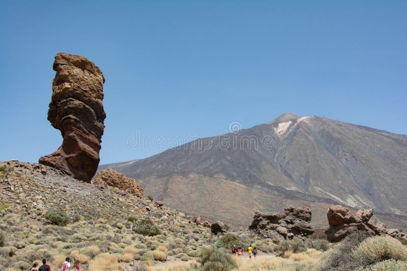 The bizarrely shaped Roque Cinchado rock of volcanic rock in Teide National Park on the Canary Island of Tenerife, Spain. With views of Mount Teide and blue skies. The bizarrely shaped Roque Cinchado rock of volcanic rock in Teide National Park on the Canary Island of Tenerife, Spain. With views of Mount Teide and blue skies