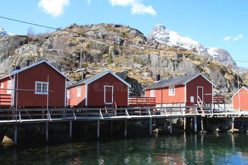 Rorbuer três velho que espelha em Nusfjord foto de stock Rorbuer três velho que espelha em Nusfjord foto de stock