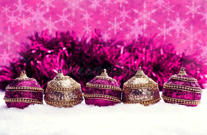 Rosa e roxo e bolas do Natal do ouro na neve com ouropel e flocos de neve, fundo do Natal imagem de stock royalty free Rosa e roxo e bolas do Natal do ouro na neve com ouropel e flocos de neve, fundo do Natal imagem de stock royalty free