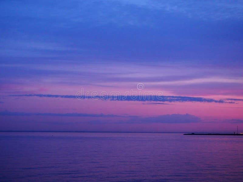 Rosa multi-colorido crepuscular e céu azul no por do sol com reflexão colorida na água do mar Paisagem marinha panorâmico no th imagem de stock Rosa multi-colorido crepuscular e céu azul no por do sol com reflexão colorida na água do mar Paisagem marinha panorâmico no th imagem de stock