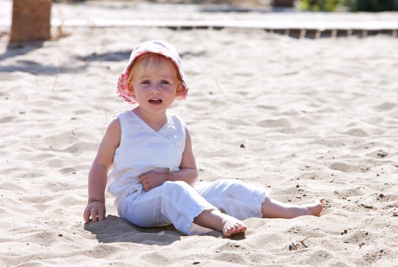 rosa sittande barn för strandbarnhatt royaltyfria bilder rosa sittande barn för strandbarnhatt royaltyfria bilder