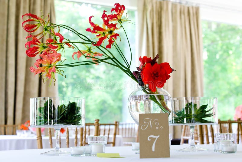Rosa und roter Blumenstrauß von Orchideenblumen auf einer Tabelle in den klaren Gläsern Wasser während einer Heiratsfeier lizenzfreie stockfotos Rosa und roter Blumenstrauß von Orchideenblumen auf einer Tabelle in den klaren Gläsern Wasser während einer Heiratsfeier lizenzfreie stockfotos