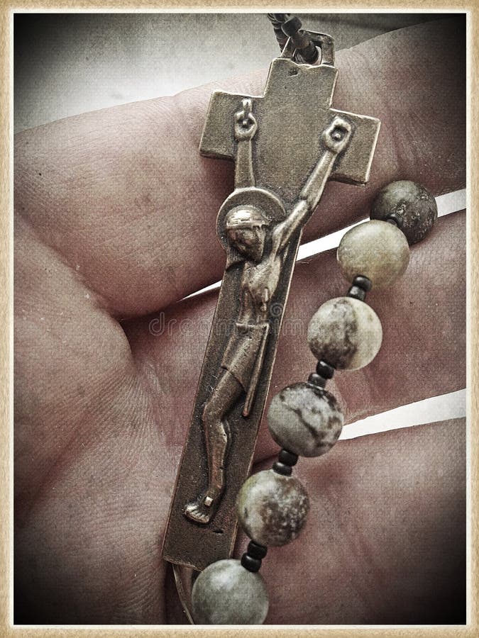 Image of a male hand holding a single decade rosary and crucifix