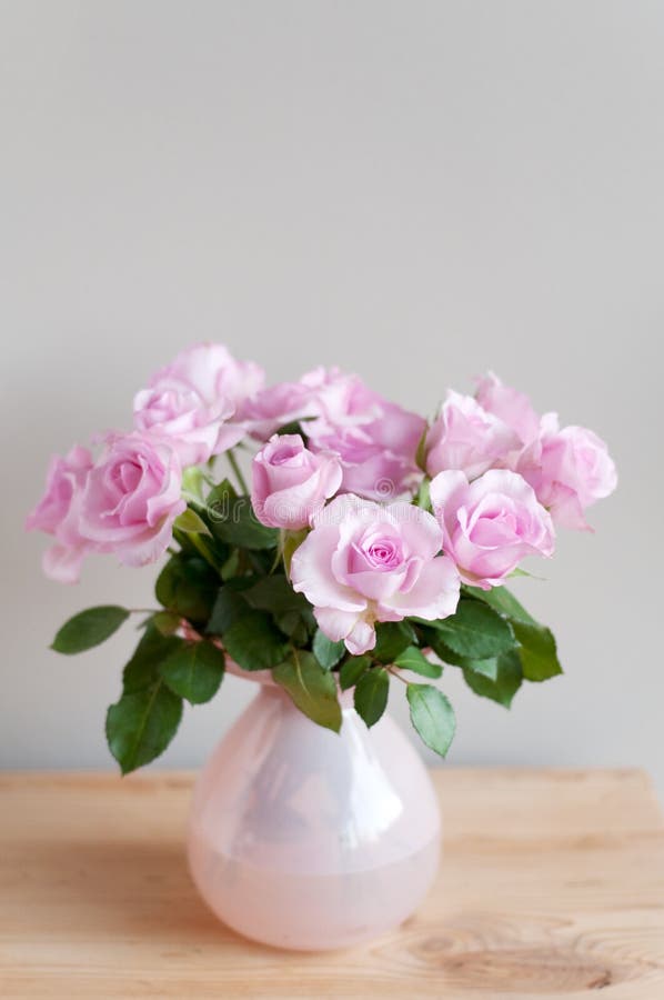 Pink roses in interior on gray wall. Pink roses in interior on gray wall