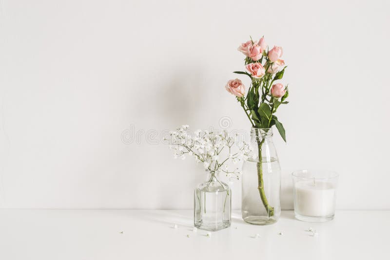 Roses, gypsophila and candle on table wall background. Romantic mockup template. Elegant minimalist. Roses, gypsophila and candle on table wall background. Romantic mockup template. Elegant minimalist.