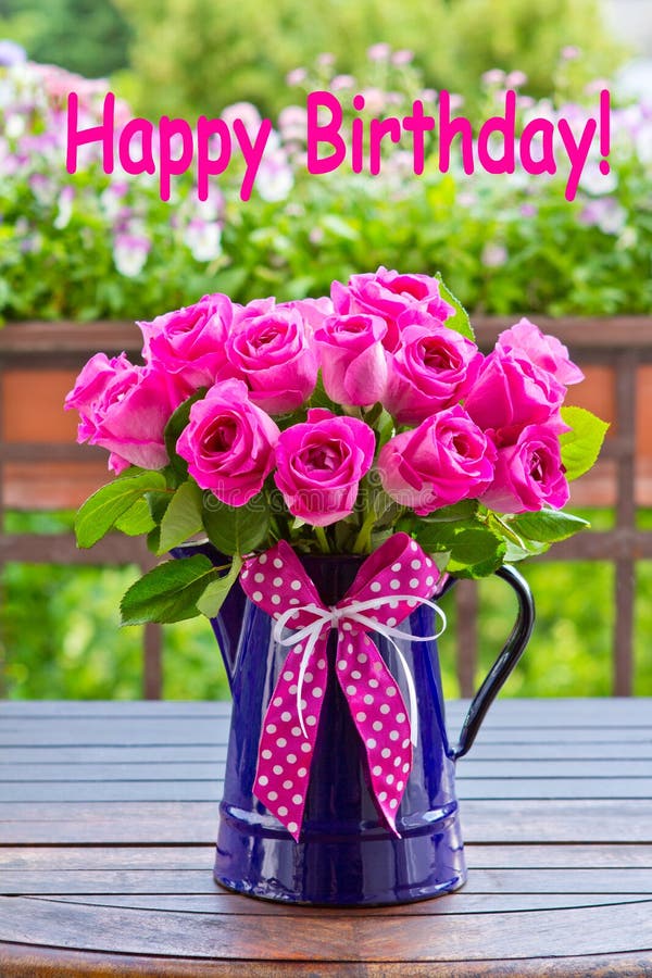 Bouquet of pink roses in a blue enamel jug with a bow of pink ribbon outdoors, text, happy birthday. Bouquet of pink roses in a blue enamel jug with a bow of pink ribbon outdoors, text, happy birthday