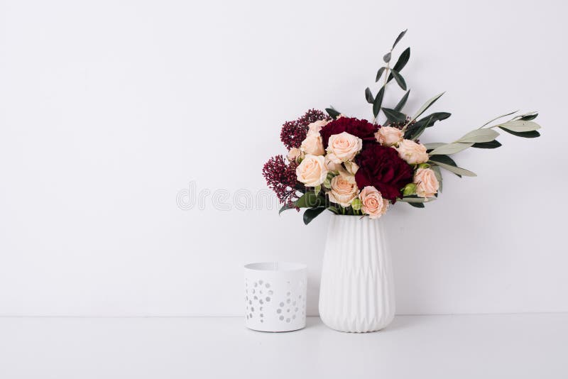 Rose e garofani in un vaso nell'interno bianco fotografie stock libere da diritti Rose e garofani in un vaso nell'interno bianco fotografie stock libere da diritti