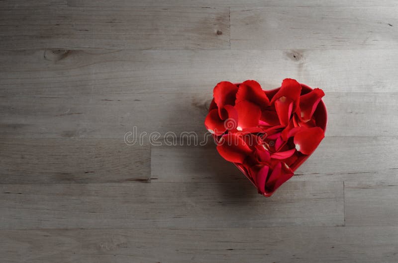Rose Petals en cuenco en forma de corazón en la madera desde arriba fotografía de archivo Rose Petals en cuenco en forma de corazón en la madera desde arriba fotografía de archivo