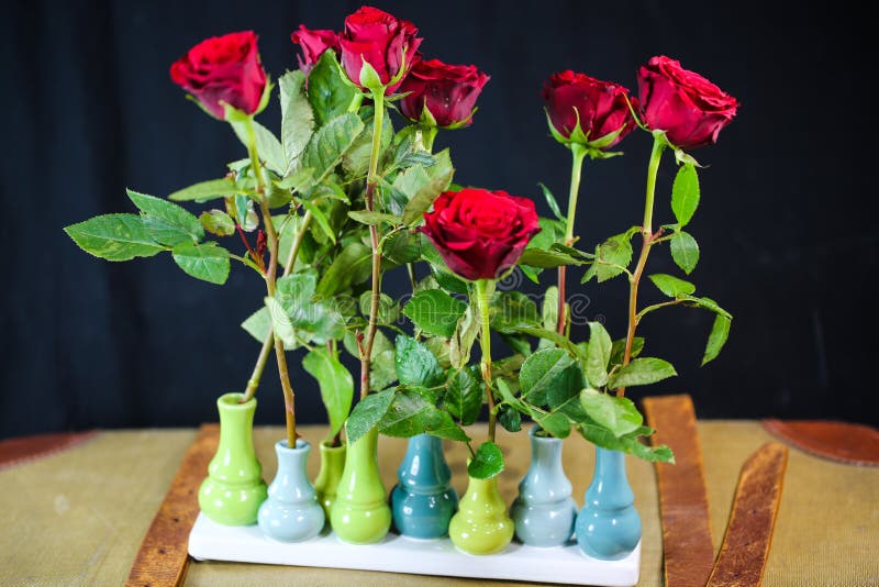 Rose rosse sulle vecchie valigie, fondo nero immagine stock Rose rosse sulle vecchie valigie, fondo nero immagine stock