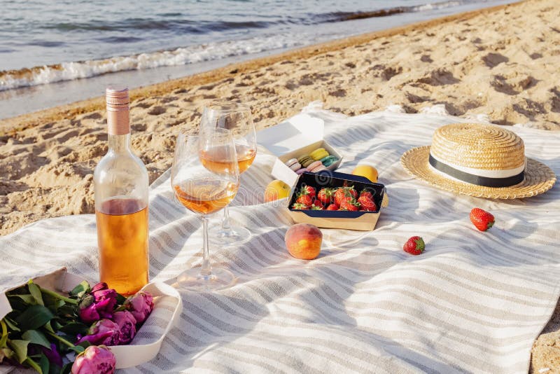 Rose wine, peaches and strawberries on the beach.