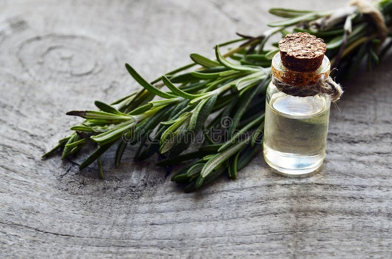Rosemary etherische olie in een glasfles met vers groen rozemarijnkruid op oude houten lijst Rosemary olie voor aromatherapy kuur royalty-vrije stock fotografie Rosemary etherische olie in een glasfles met vers groen rozemarijnkruid op oude houten lijst Rosemary olie voor aromatherapy kuur royalty-vrije stock fotografie