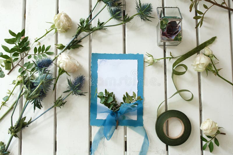 Roses blanches fraîches et épouser la carte d'invitation sur les ventres en bois blancs images libres de droits Roses blanches fraîches et épouser la carte d'invitation sur les ventres en bois blancs images libres de droits