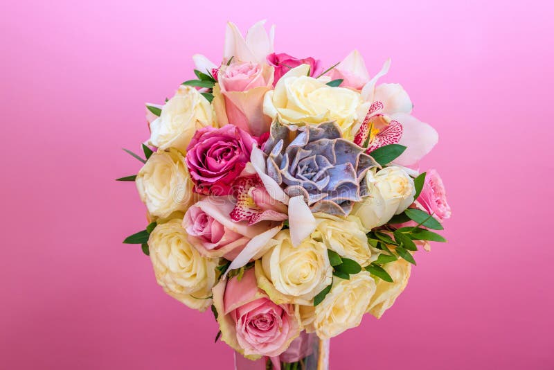 Roses in a brides flower bouquet on pink wall background behind