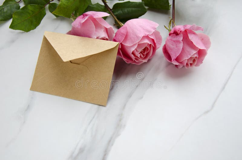 Roses and a craft envelope as a symbol of valentines day. Bouquet of roses,letter as a gift.Valentines day concept Roses and a craft envelope as a symbol of stock photos Roses and a craft envelope as a symbol of valentines day. Bouquet of roses,letter as a gift.Valentines day concept Roses and a craft envelope as a symbol of stock photos