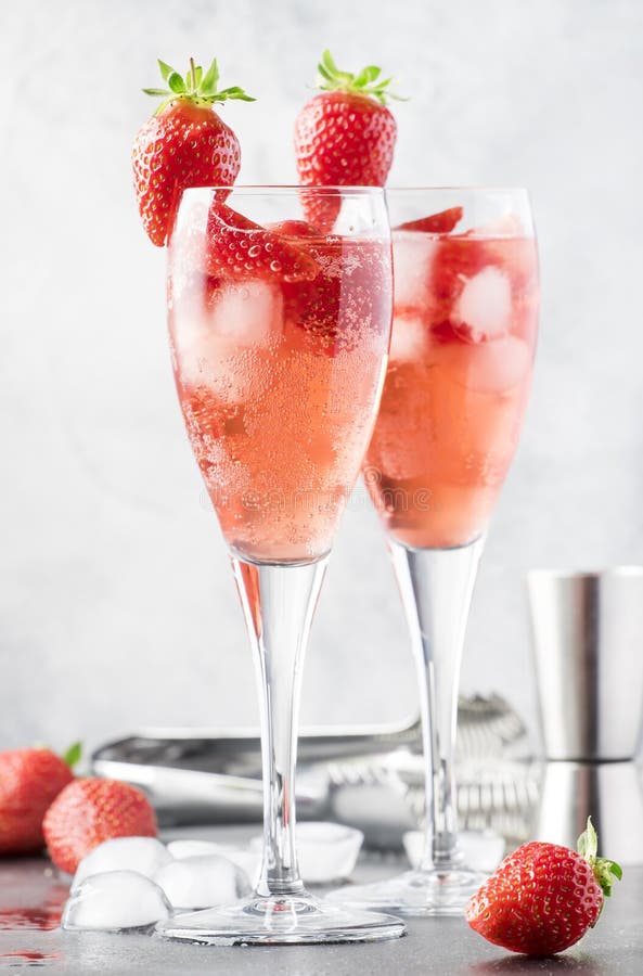 Rossini alcoholic cocktail with Italian sparkling wine, strawberry puree and ice in champagne glasses, place for text, selective  focus