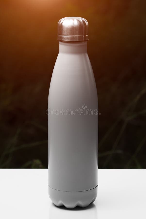 Rostfreie Thermo Flasche für Wasser, Tee und coffe, auf weißer Tabelle Dunkler Grashintergrund mit Sonnenlichteffekt Silberne Far lizenzfreies stockbild Rostfreie Thermo Flasche für Wasser, Tee und coffe, auf weißer Tabelle Dunkler Grashintergrund mit Sonnenlichteffekt Silberne Far lizenzfreies stockbild