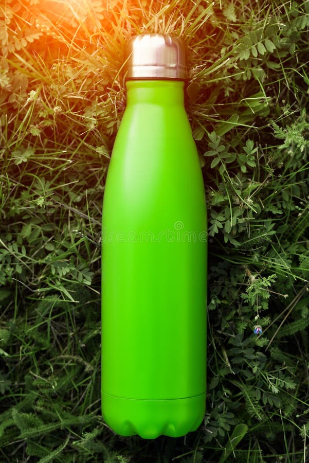 Rostfreie Thermosflaschewasserflasche, hellgrüne Farbe Modell auf Hintergrund des grünen Grases mit Sonnenlichteffekt stockbild Rostfreie Thermosflaschewasserflasche, hellgrüne Farbe Modell auf Hintergrund des grünen Grases mit Sonnenlichteffekt stockbild